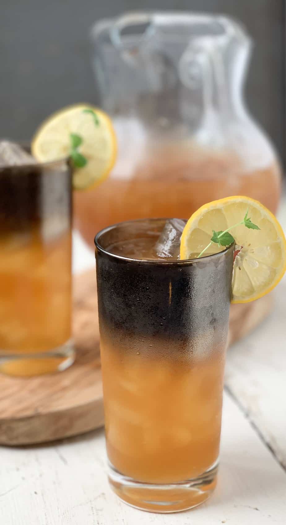 glass of arnold palmer with a pitcher in the background.