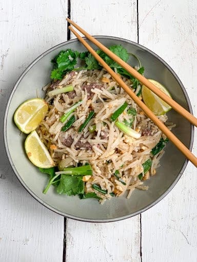 beef pad thai in a shallow bowl. 