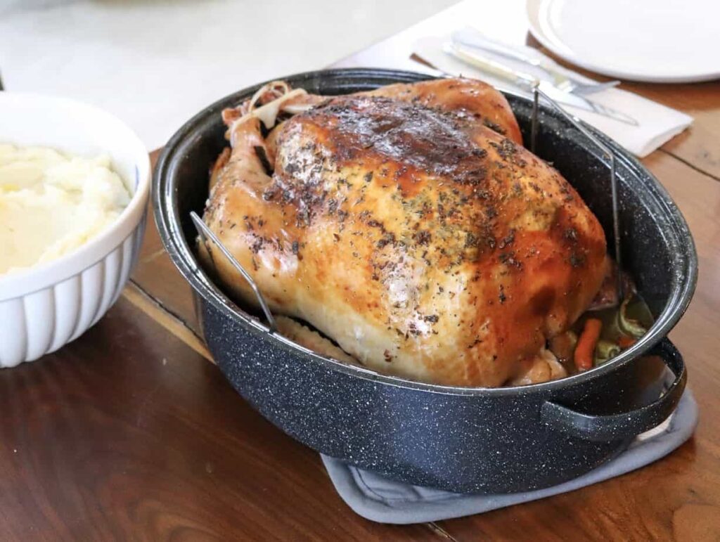 roasted turkey on a table with mashed potatoes to the side