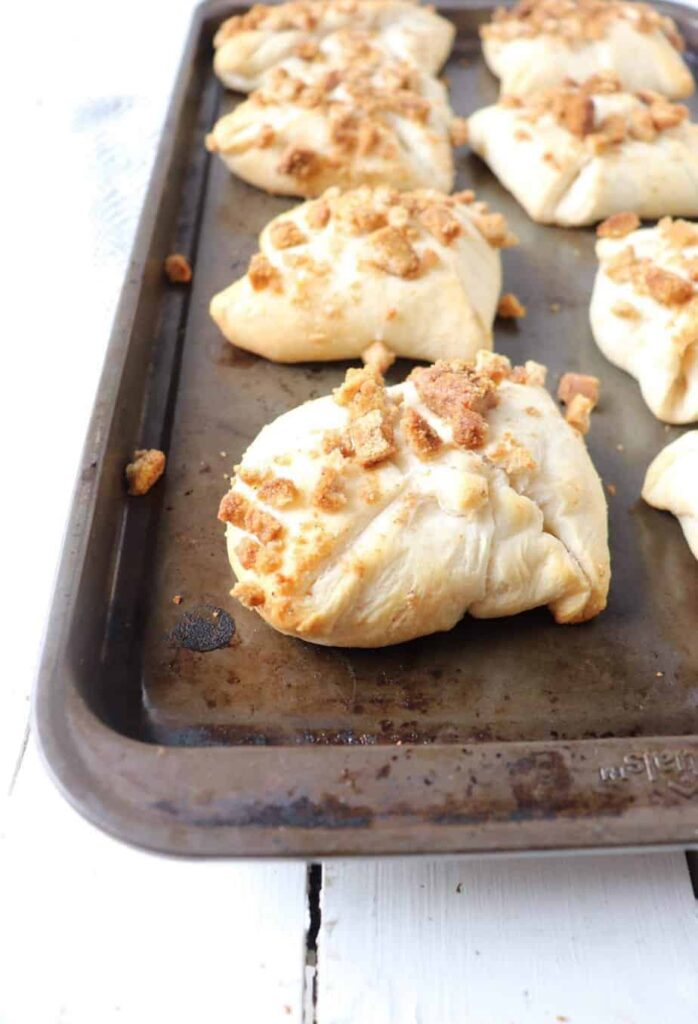 8 baked chicken pillows on a dark grey baking sheet 