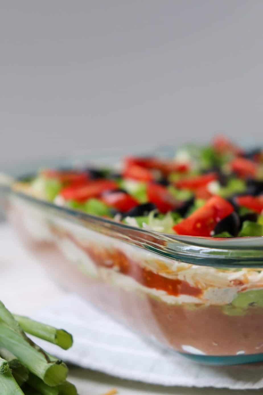 side view of the layers of taco dip in a glass dish.