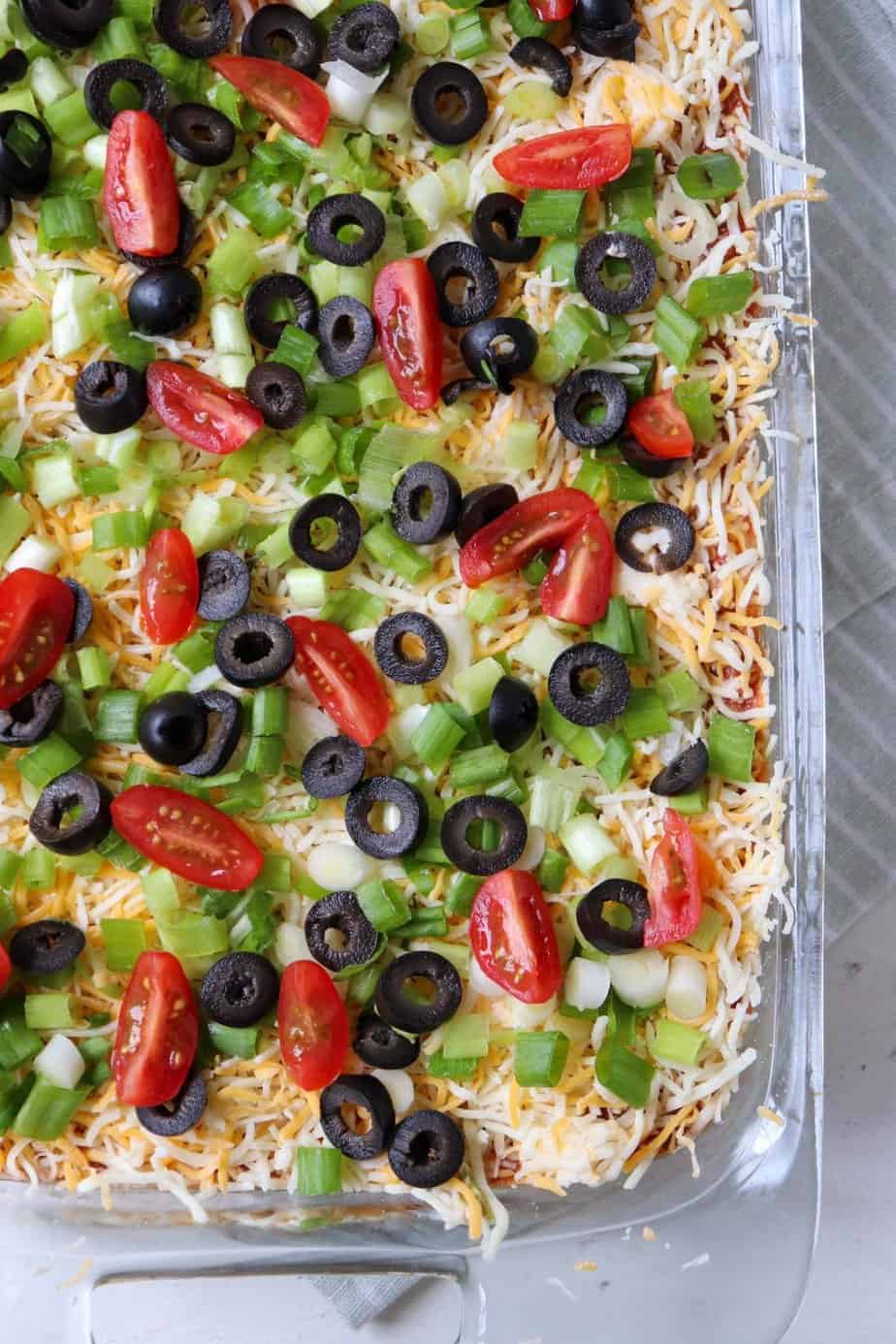 finished taco dip with lots of toppings.