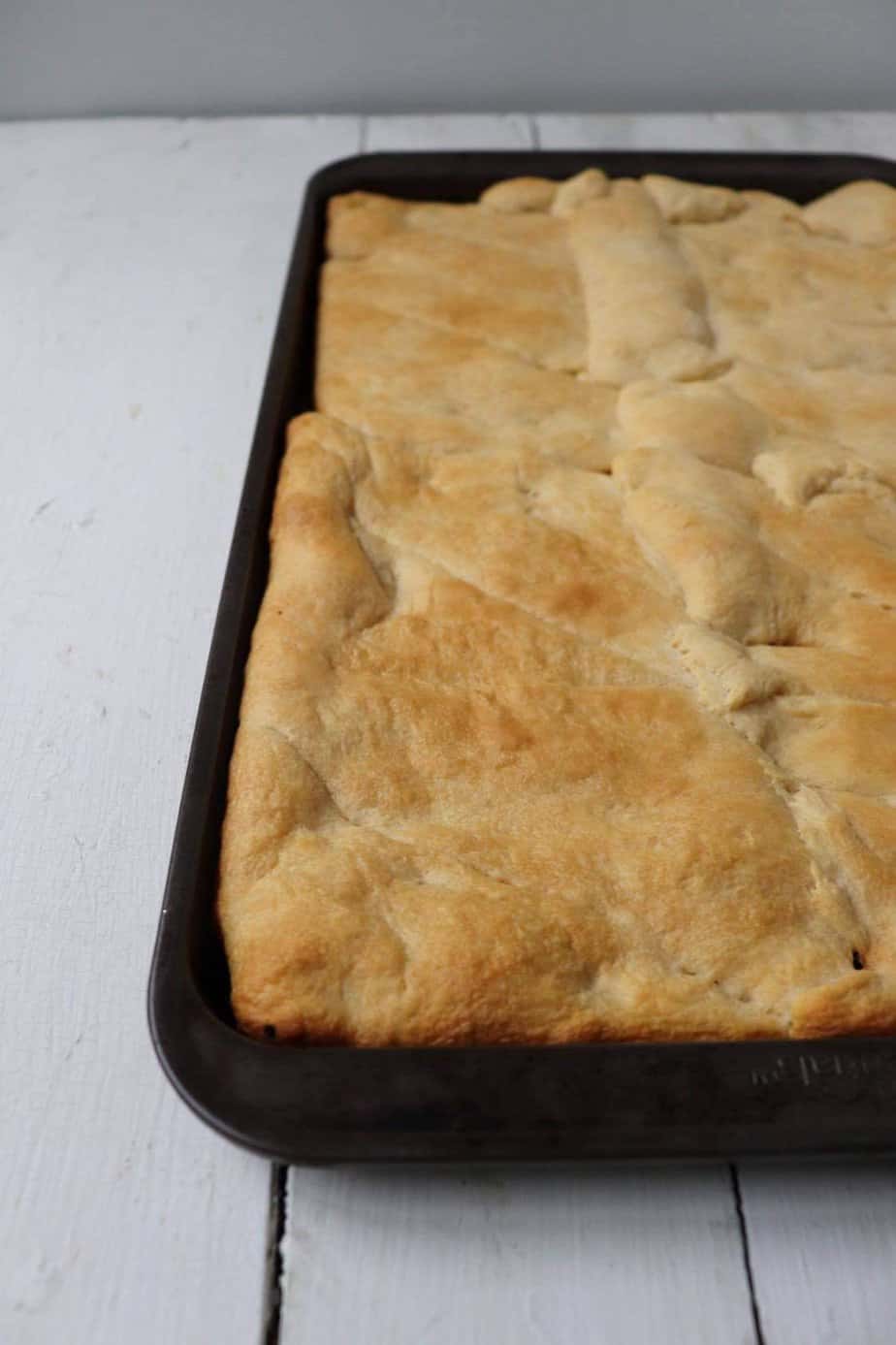 cooked crescent rolls that have been rolled out in a baking sheet. 