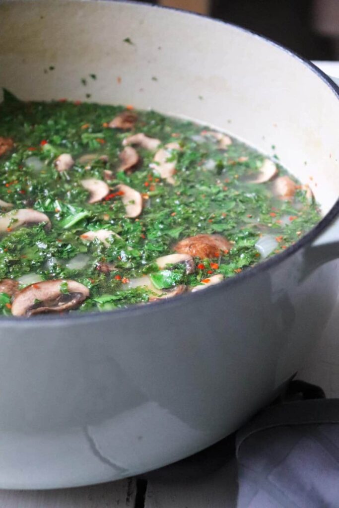 angled side shot of soup in a minty blue dutch oven