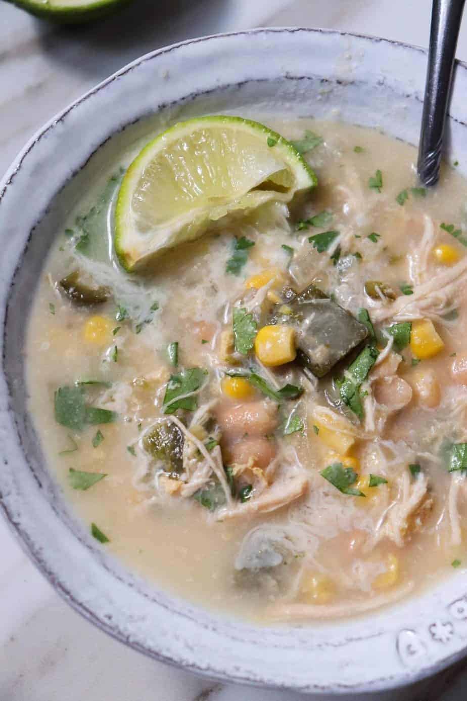 bowl of white bean and poblano soup topped with a lime wedge.