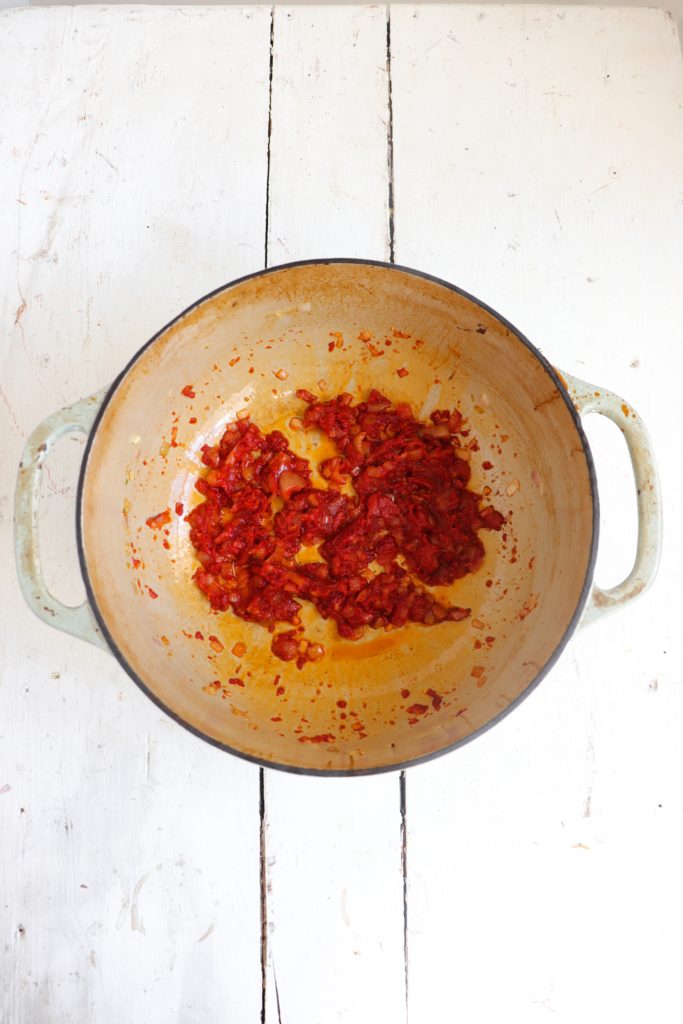 tomato paste in a large pot on a white background