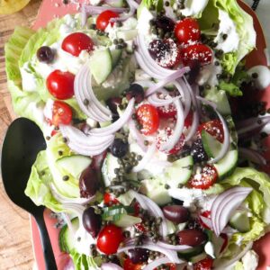 greek wedge salad halves on a large platter.