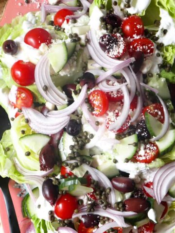 greek wedge salad halves on a large platter.