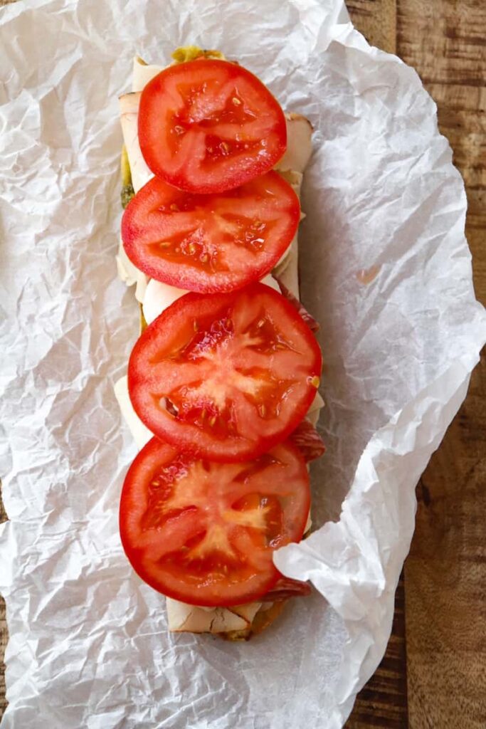 tomato slices added to baguette half.