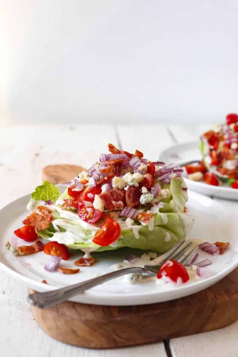 baby iceberg wedge salad on a white plate.