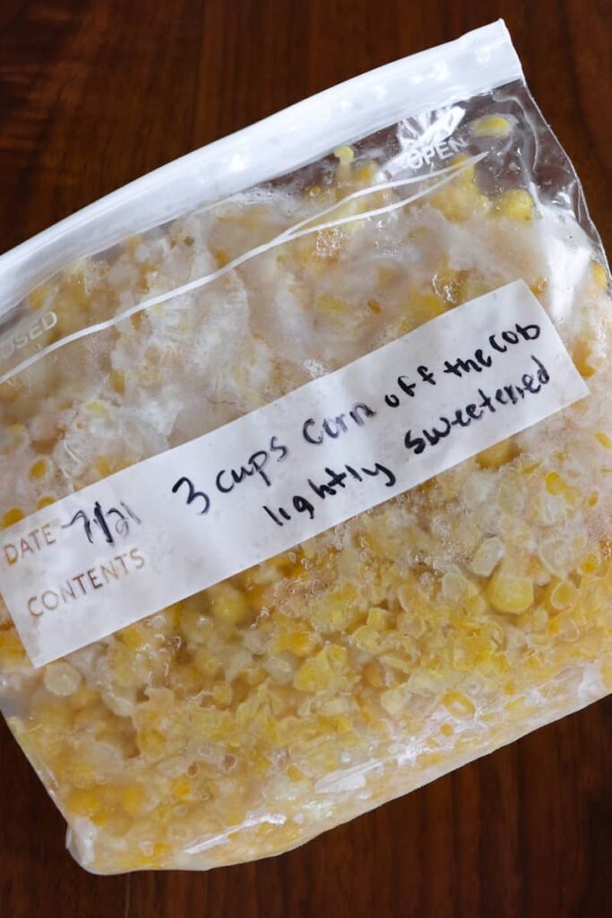 frozen corn in a quart sized freezer bag labeled with date, amount, and lightly sweetened