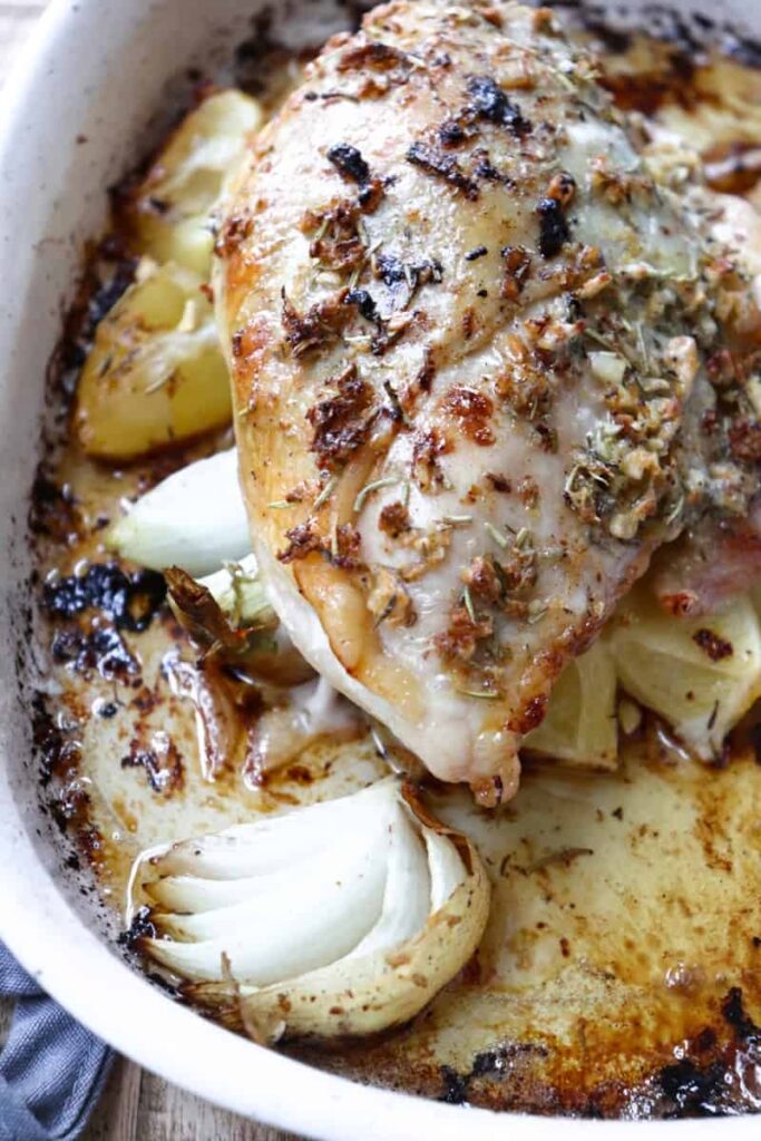 baked chicken on a bed of onions and lemons