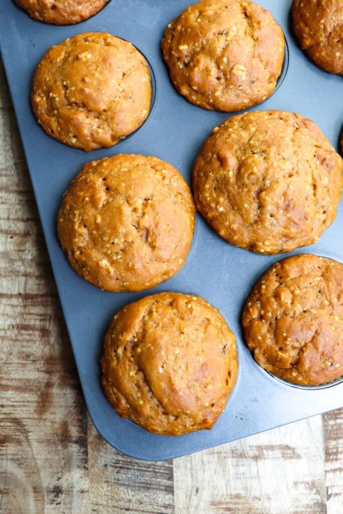 baked pumpkin muffins in dark gray muffin tin