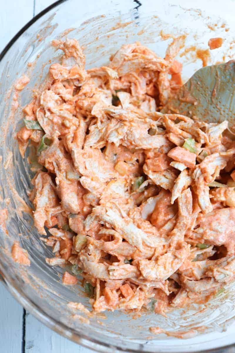 buffalo chicken mixture in a bowl with a spoon in the bowl
