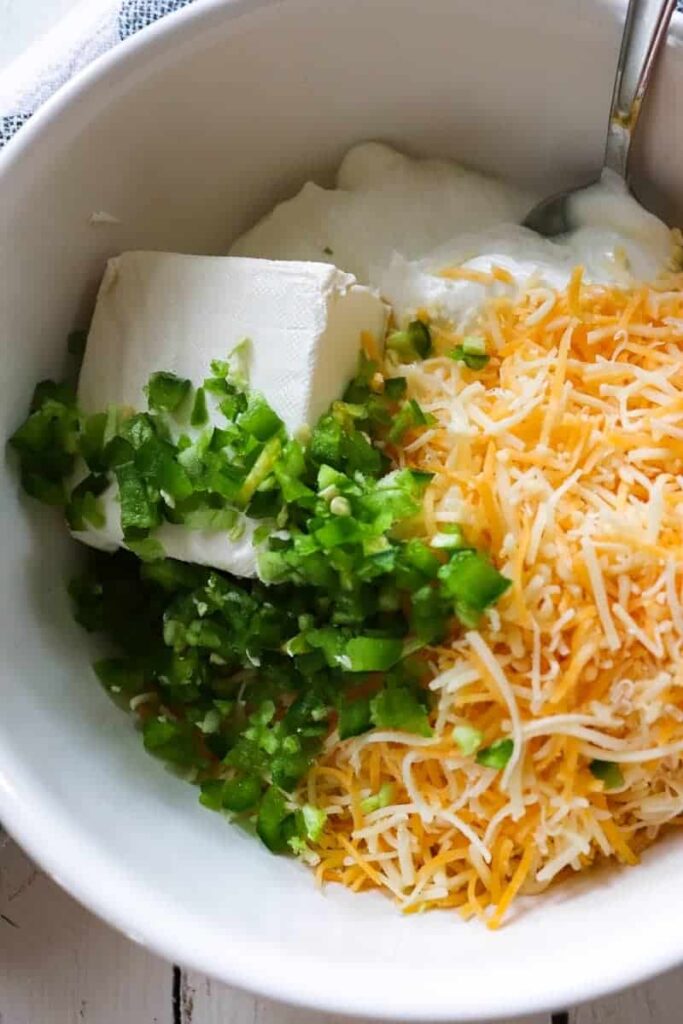 unmixed ingredients for jalapeno cream cheese filling shown in a white bowl