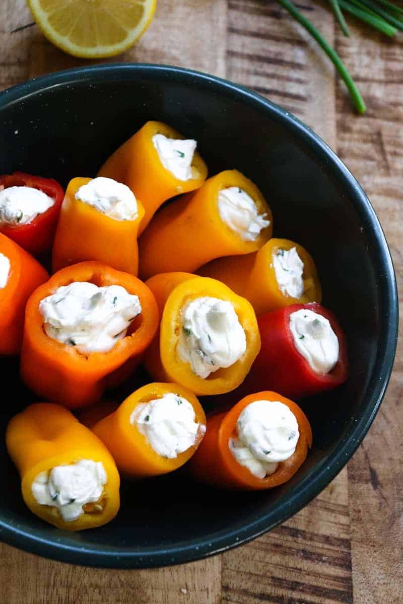 stuffed mini peppers with cream cheese filling in a dark green bowl