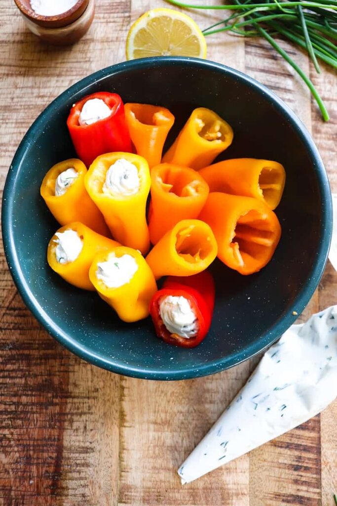 peppers half completed in a bowl with filling to the side