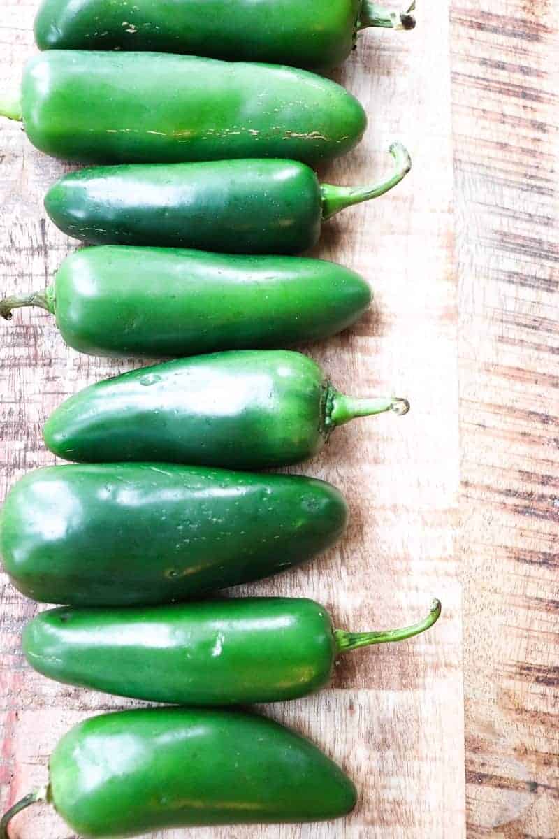 multiple jalapeno fruits lined up in a row