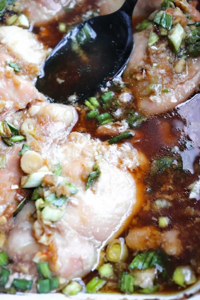 completed teriyaki chicken thighs with a spoon in the dish