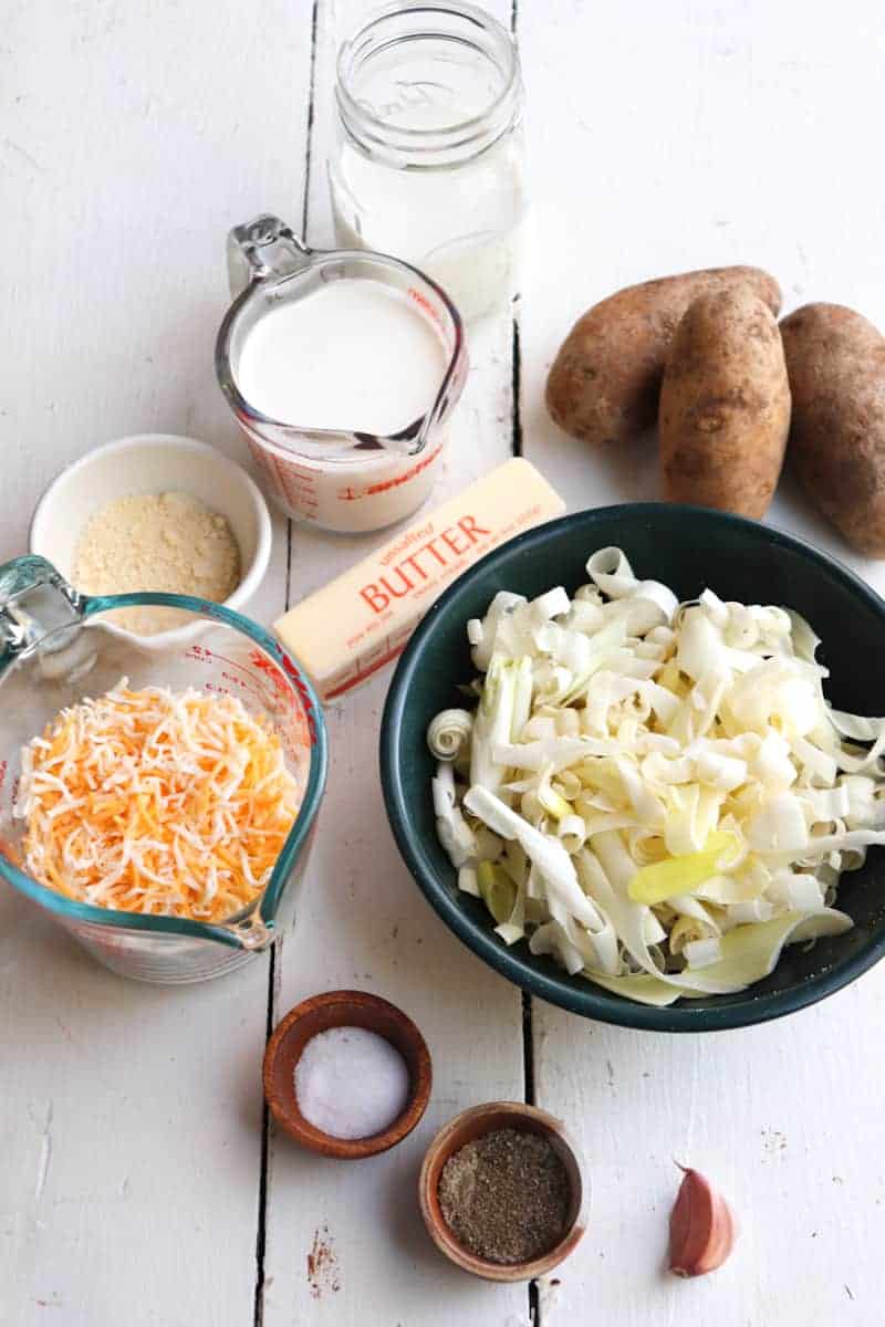 ingredients for leek and potato gratin on a white wooden background