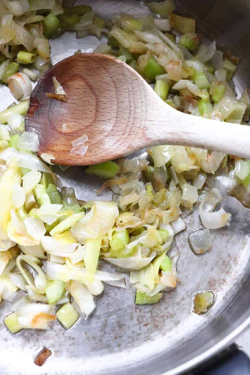 sauteed leeks with a wooden spoon to stir