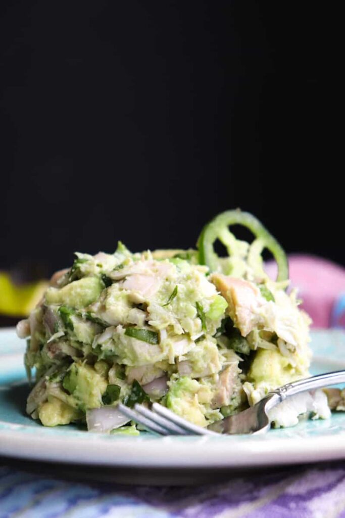 avocado chicken salad on a blue plate with a jalapeno on top