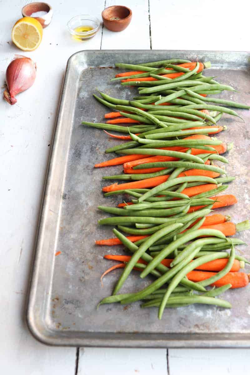 carrots and green beans trimmed and placed on a metal sheet pan