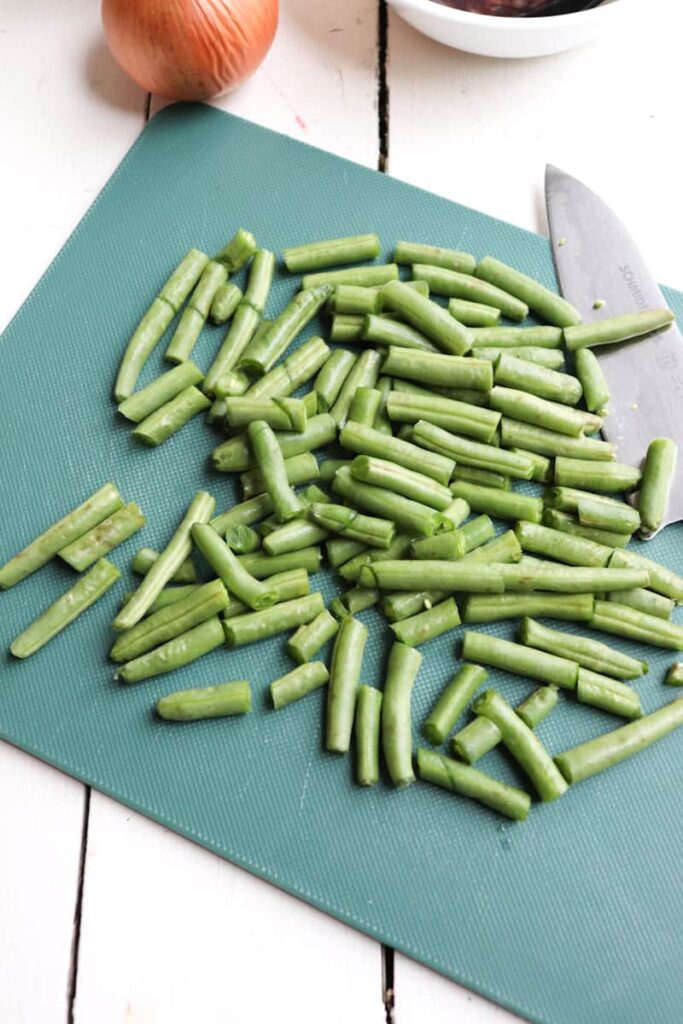 chopped green beans on a green cutting board