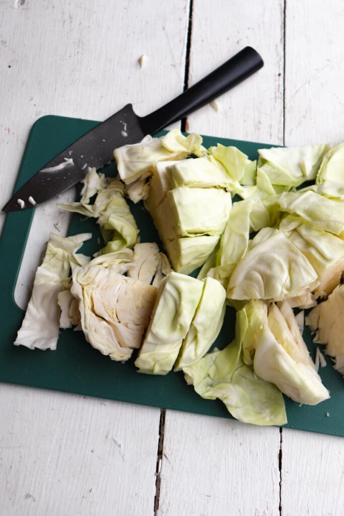 cabbage that has been cut into strips on a green cutting board
