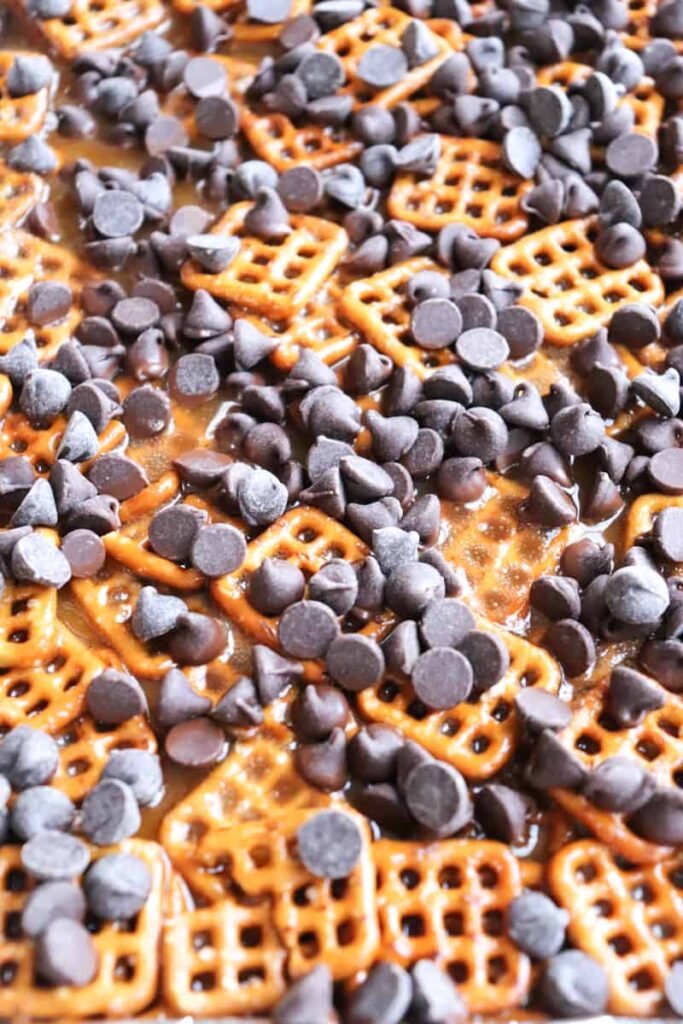 chocolate chips sprinkled over top of pretzels