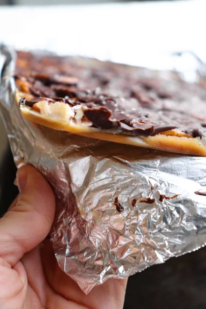 foil being peeled back from chocolate pretzel candy 