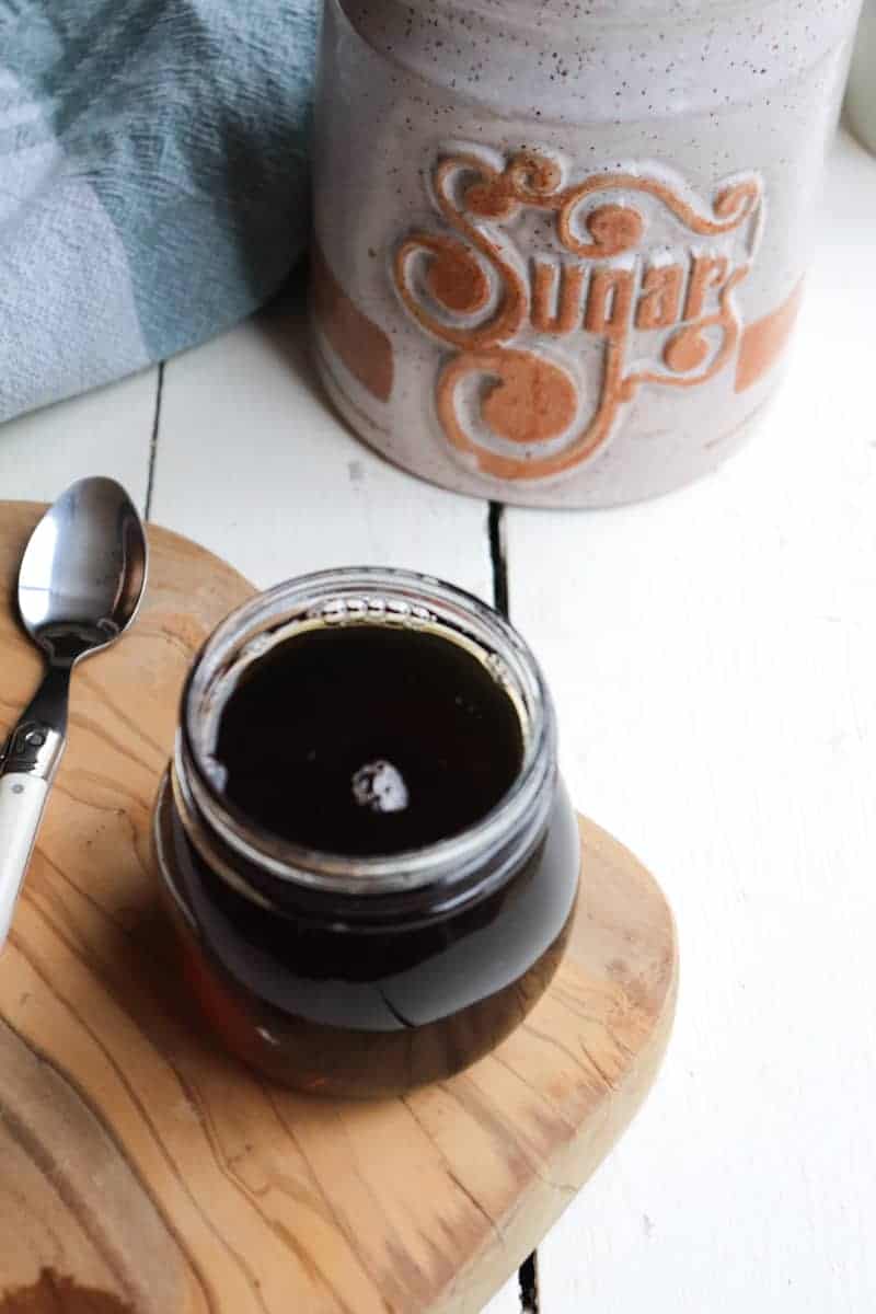 syrup in a small glass jar with a spoon to the side