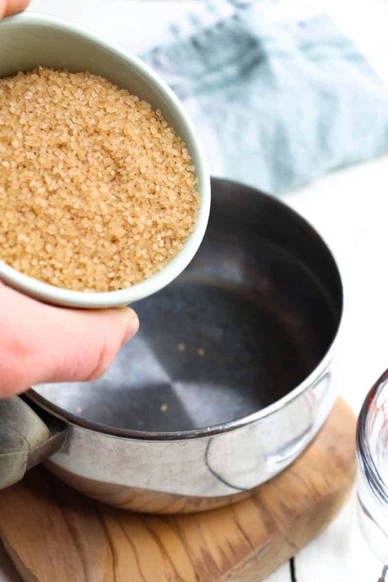 demerara sugar being poured into a small saucepan