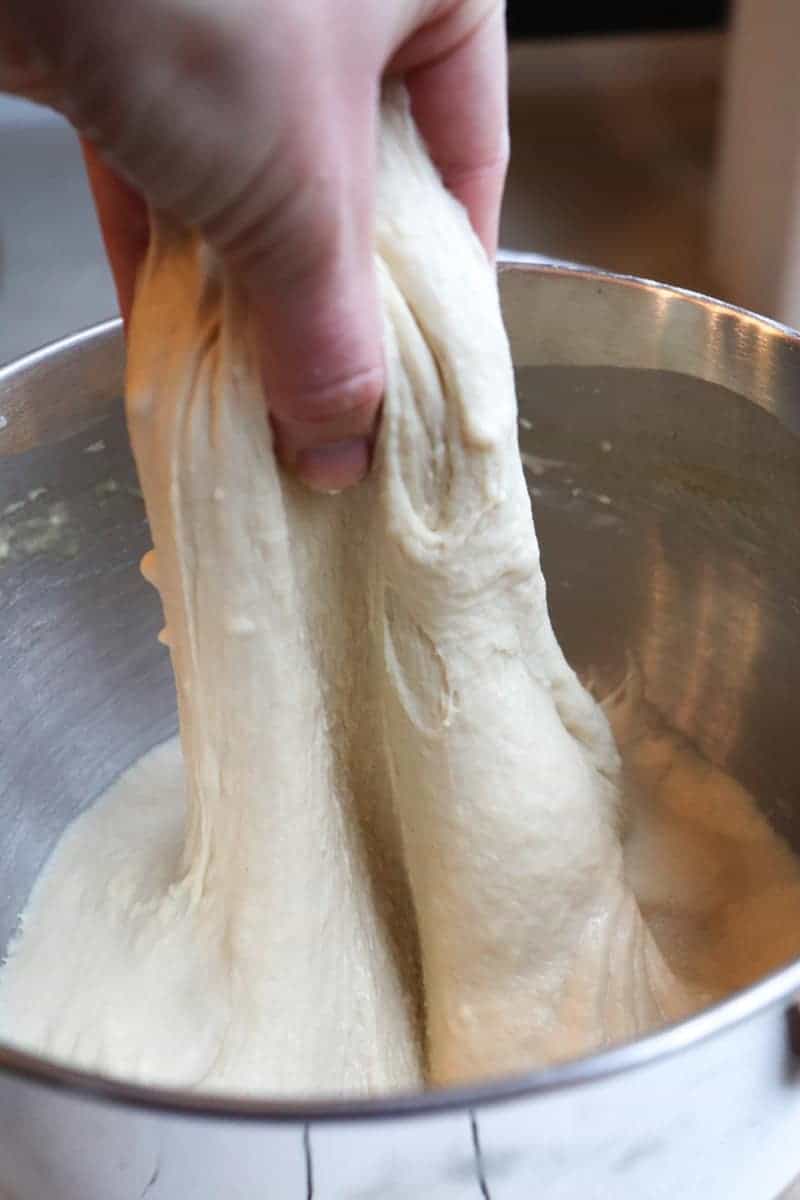sourdough being pulled up by hand to stretch 