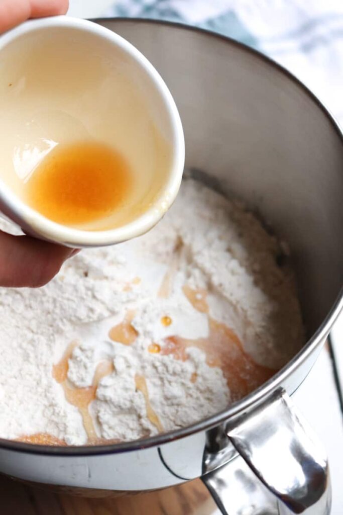 honey being added to flour from a small cream ramekin 