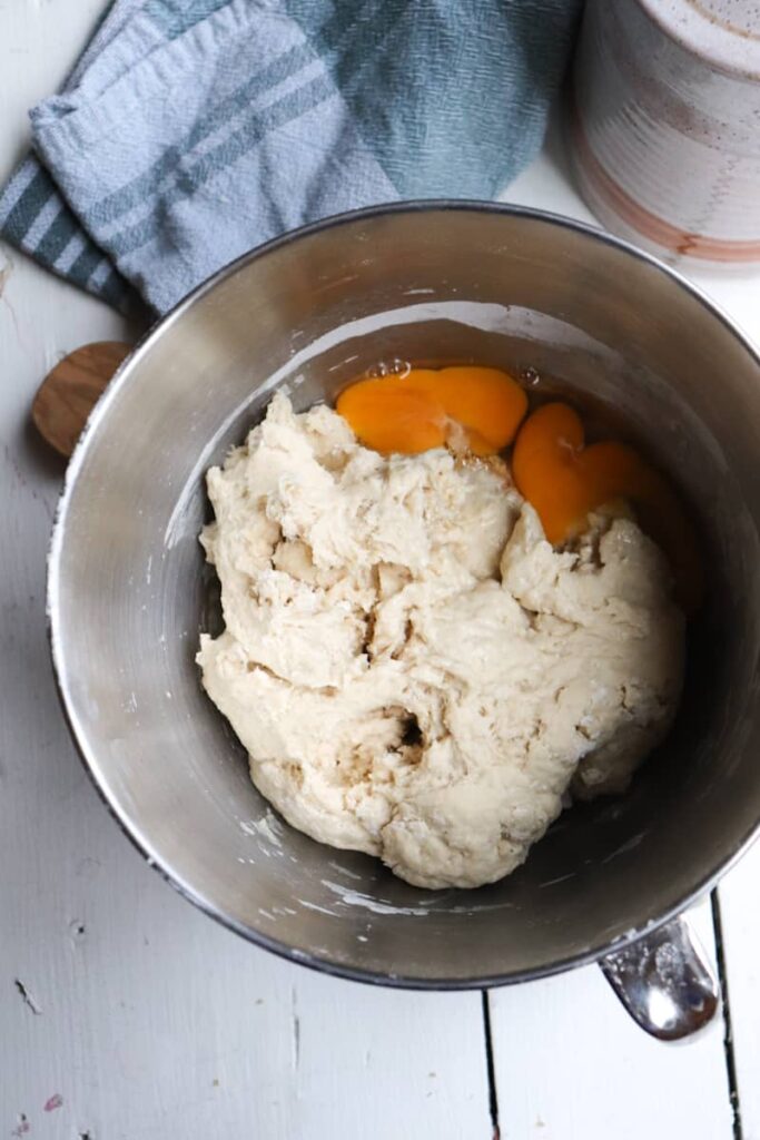 bowl of stand mixer with dough with eggs added