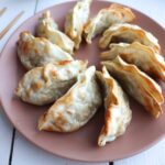 air fried potstickers on a light pink plate