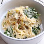 bowl of lemon ricotta pasta with microplane in the background