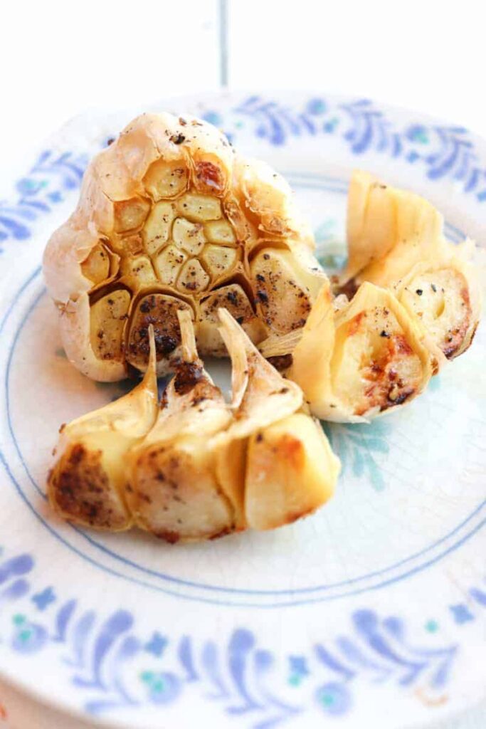 roasted garlic bulb on a decorative plate