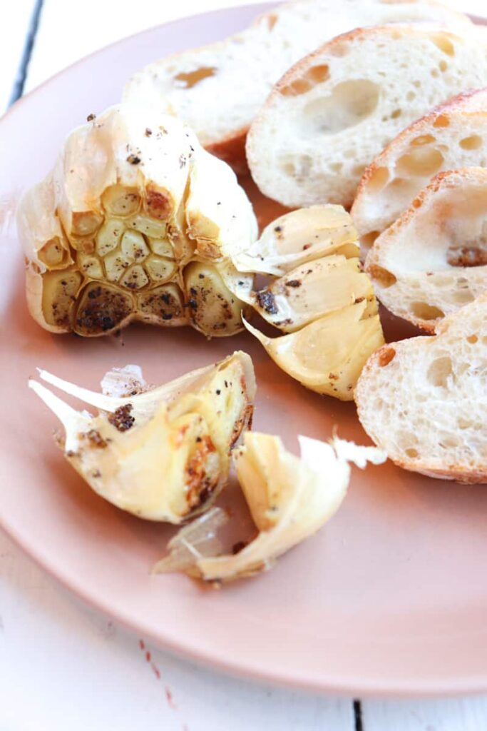 roasted garlic on a plate with bread slices