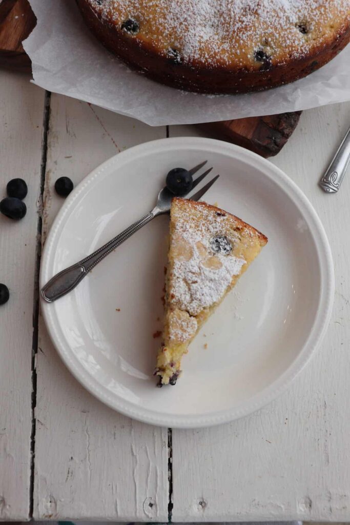 cake slice with a fork and blueberries on the side