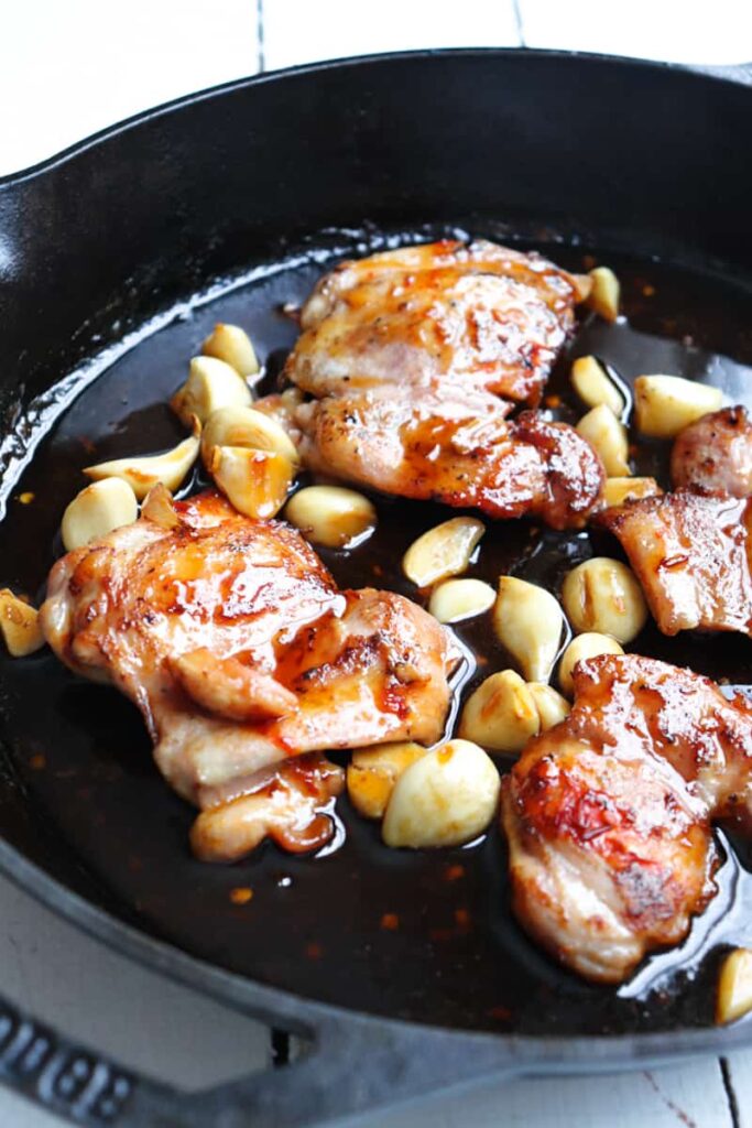 angled view of chicken thighs i ncast iron skillet