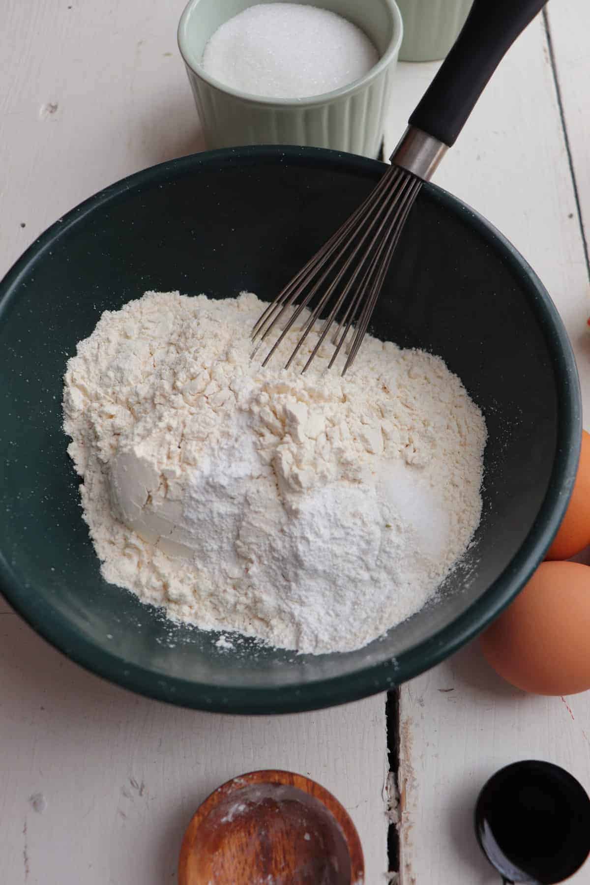 dry ingredients in a small green bowl with a whisk