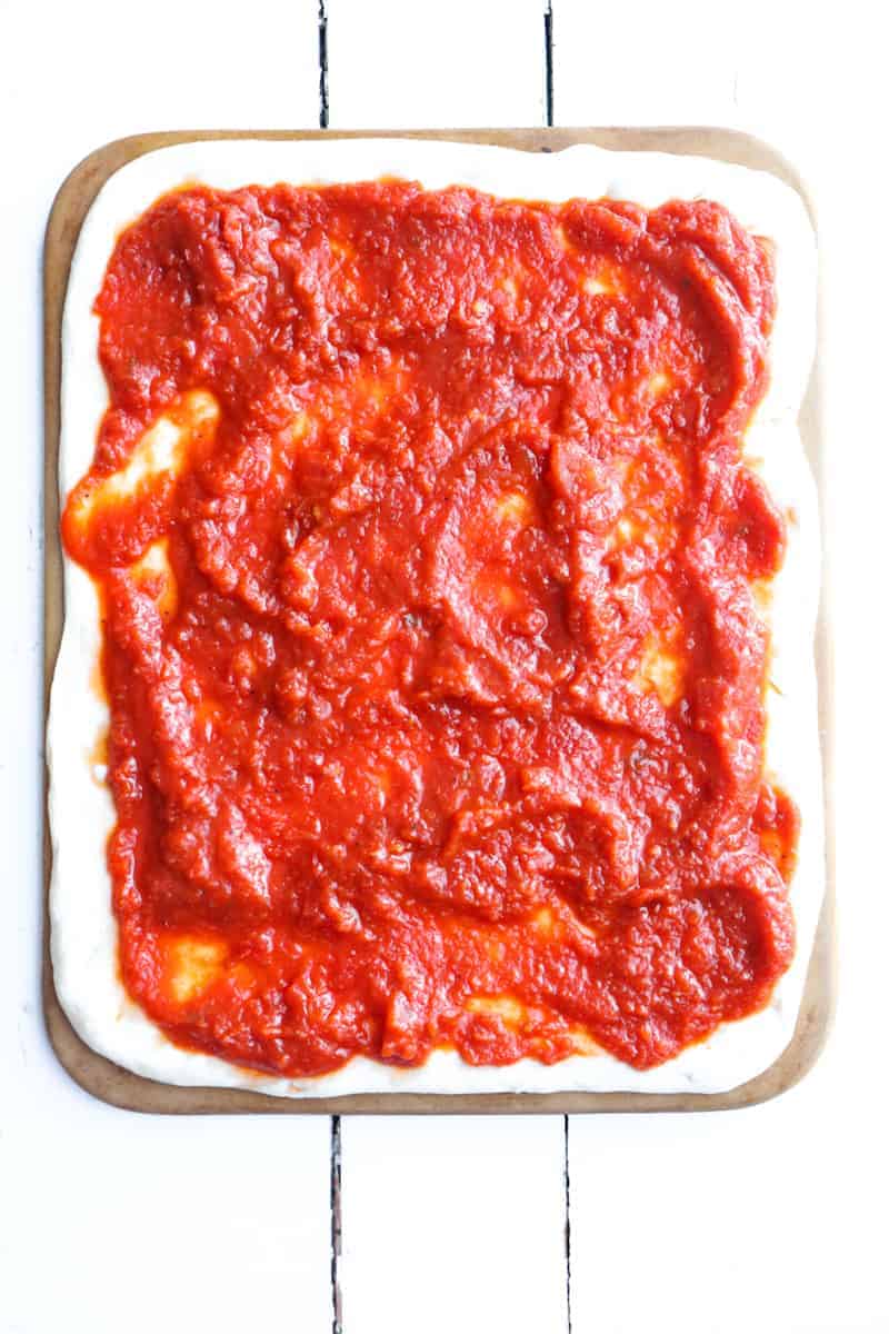 sauce covering pizza dough