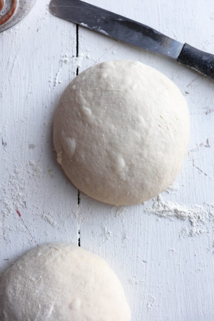 finished sourdough discard pizza dough in a ball with knife in background