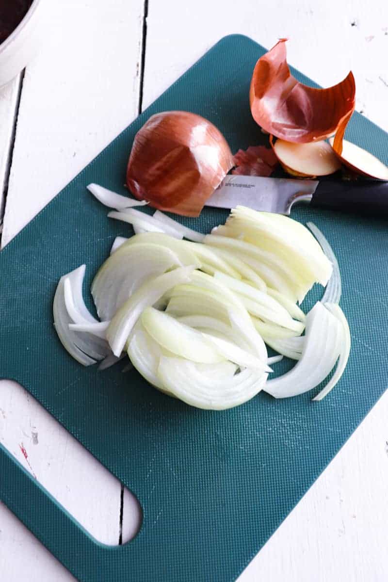 sliced onions on green cutting board