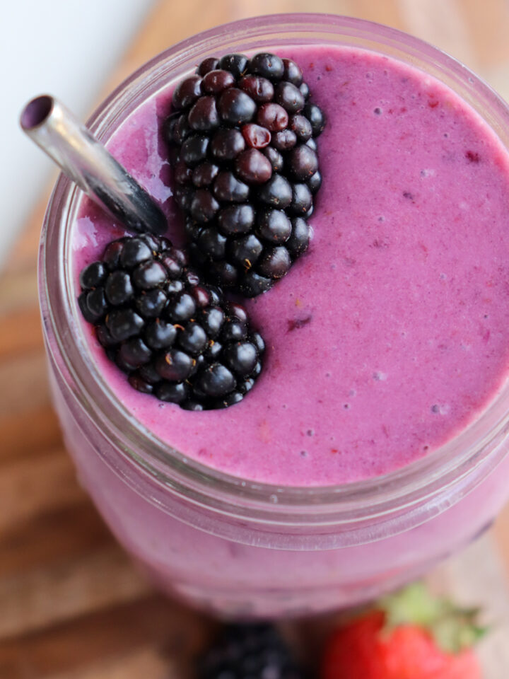 blackberry strawberry banana smoothie in a glass garnished with fresh blackberries