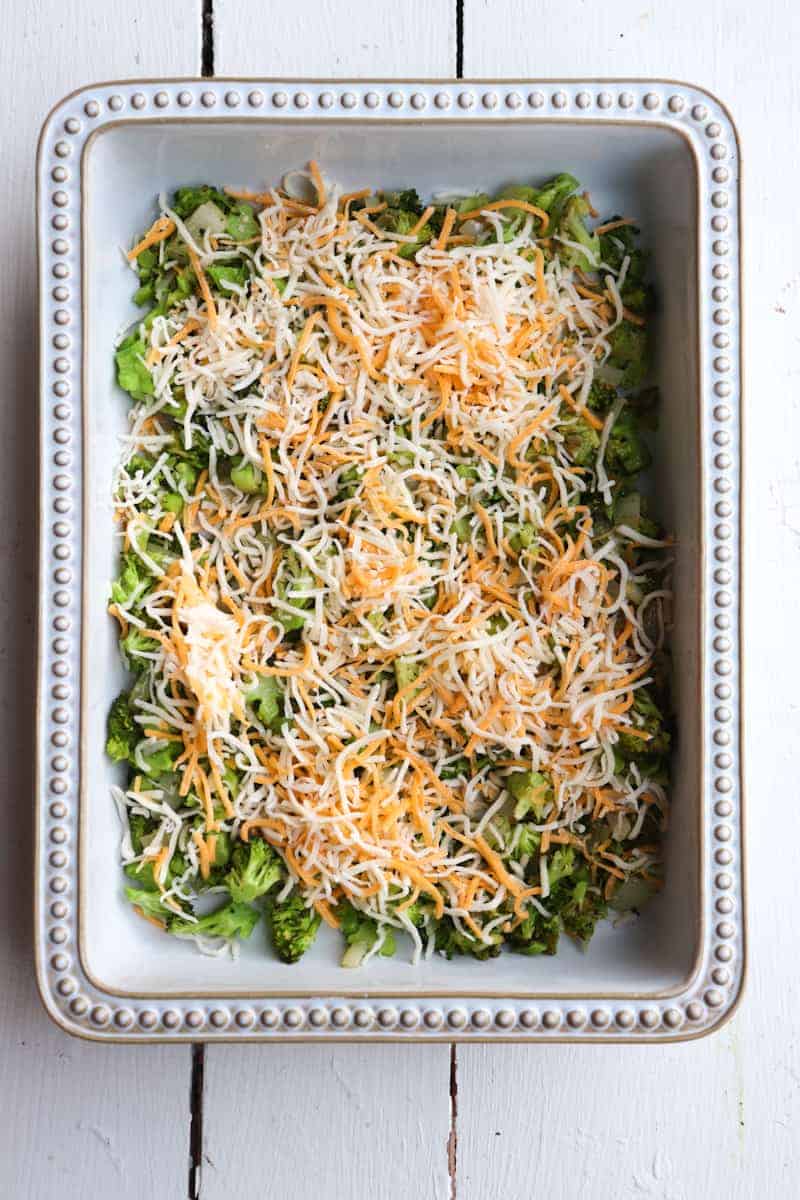cheese sprinkled on broccoli in a baking dish
