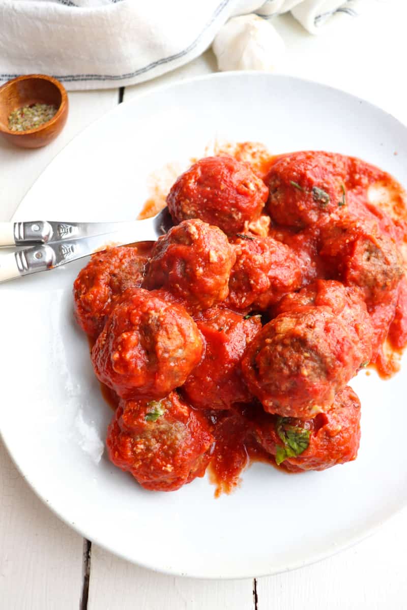 platter of finished meatballs coated in tomato sauce