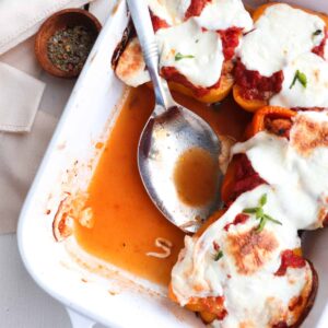 chicken parm stuffed peppers in a white dish with two removed